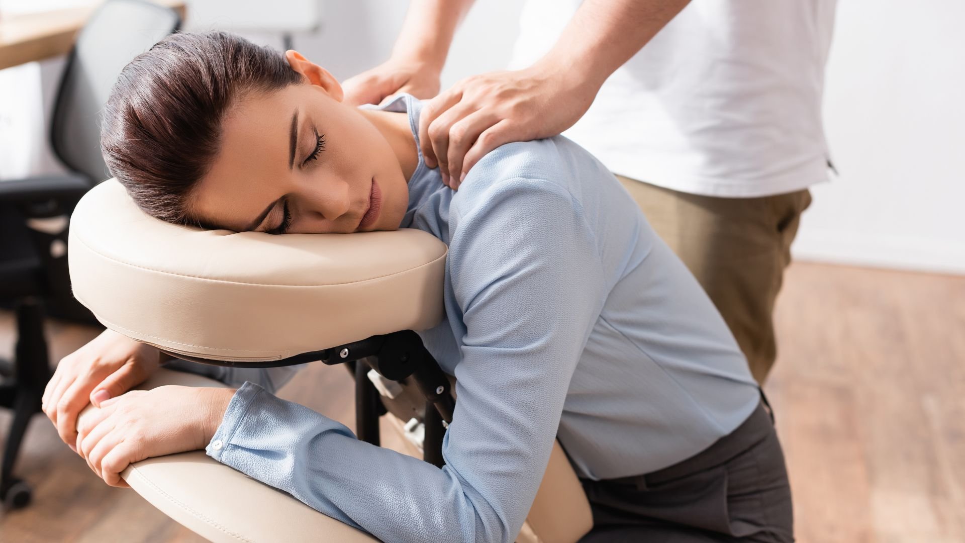 Person receiving massage therapy, resting on padded massage table